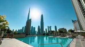 Una piscina con sullo sfondo una skyline cittadina, con un grattacielo ben visibile.