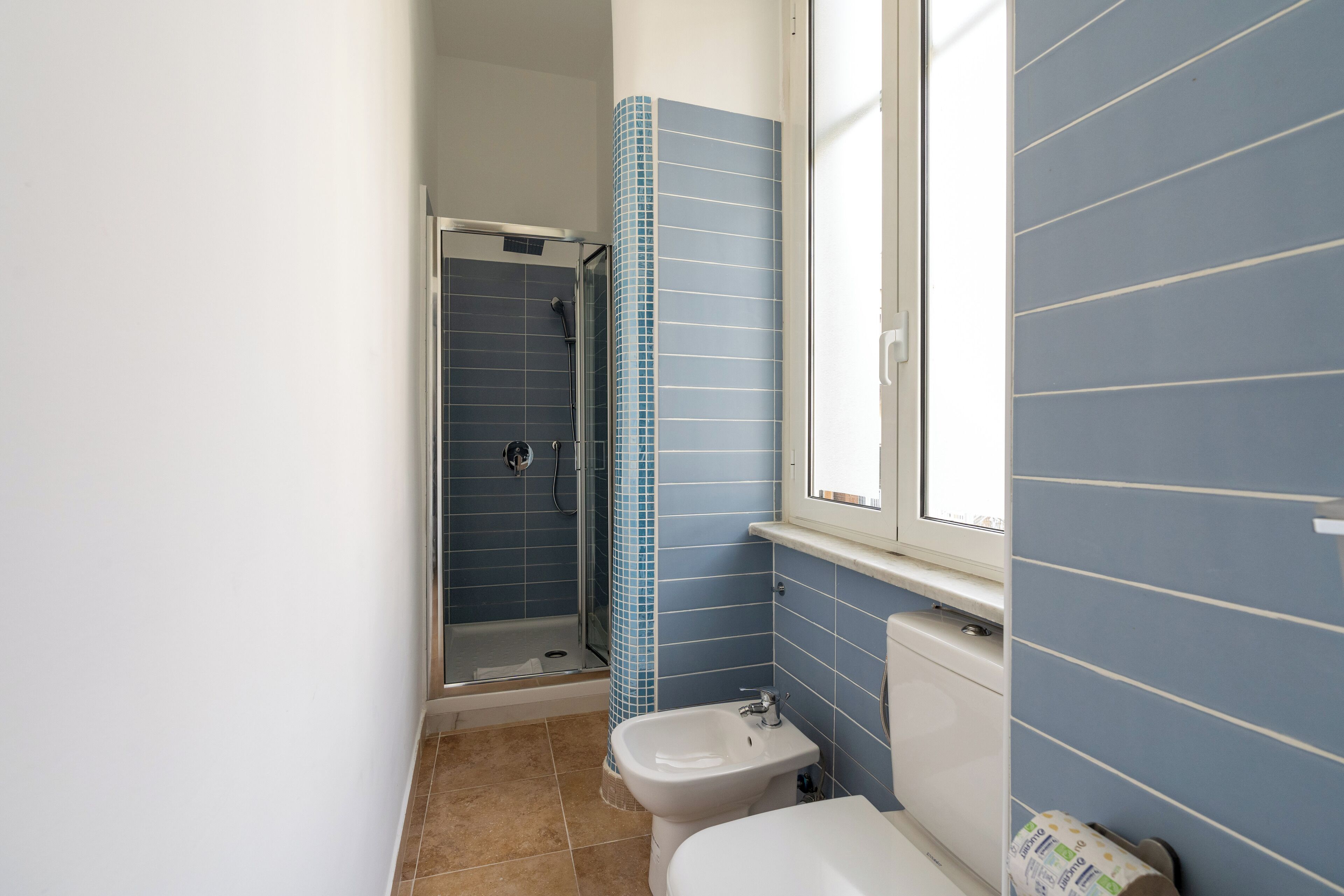 A bathroom with a shower, a sink, and a toilet.