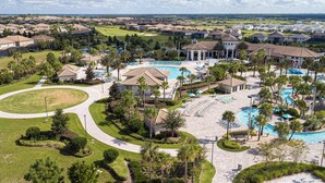 A resort with multiple swimming pools, palm trees, and a golf course in the background. - Marvelous 4 Bd w Pool Waterpark Near Disney 218 (Kissimmee)