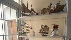 A kitchen with a window, a sink, a stove, and shelves with decorative items. - BLUE DREAM (Napoli)