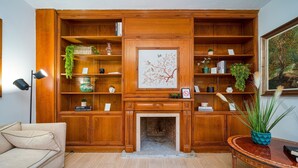 A living room with a fireplace, wooden shelving, and a sofa. - P Casa Cafe Madrid Calle Carlos Dubois 3 (Madrid)