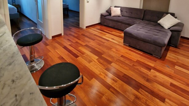 Un salon moderne avec un canapé gris, une table basse ronde et un tabouret de bar.