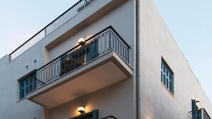 A multi-story hotel with balconies, a sign indicating it is a hotel, and a well-lit entrance. - Downtown Hotel (Nafplio)