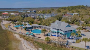 Un hôtel situé sur la côte, composé de plusieurs bâtiments, doté d’une piscine et d’un espace de plage.