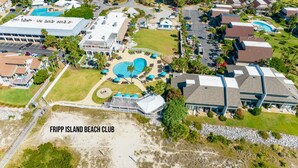 Ein Luftbild des Fripp Island Beach Club mit einem großen Pool, mehreren Gebäuden und umgebender Bepflanzung.