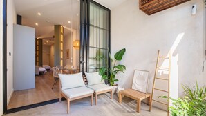 A modern interior with a sofa, a ladder, and a potted plant. - Apartment 'Mestalla Flats Rut' with Private Terrace, Wi-Fi and Air Conditioning (Valencia)