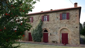 Un edificio de piedra con arcos y contraventanas rojas.