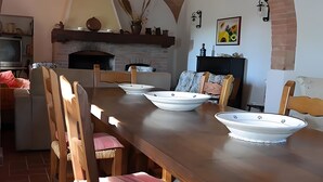 Un comedor con una larga mesa de madera, sillas y cuencos blancos decorativos.