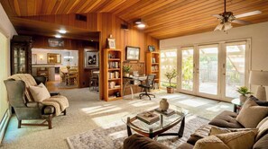 A cozy living room with a fireplace, a dining area, and a workspace with a desk and chair. - Mid-century Ojai Escape Hot Tub Serene Garden (Ojai)