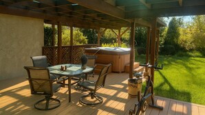 An outdoor patio with a wooden table and chairs, a hot tub, and a pergola structure. - Mid-century Ojai Escape Hot Tub Serene Garden (Ojai)