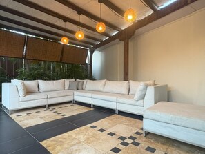 Ein modernes Wohnzimmer mit einem Ecksofa, einem kleinen Tisch und einem gemusterten Teppich.