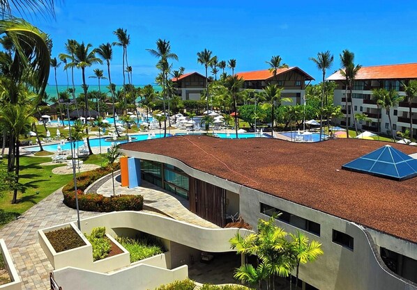 Ein Resort mit Swimmingpool, Palmen und modernen Gebäuden.