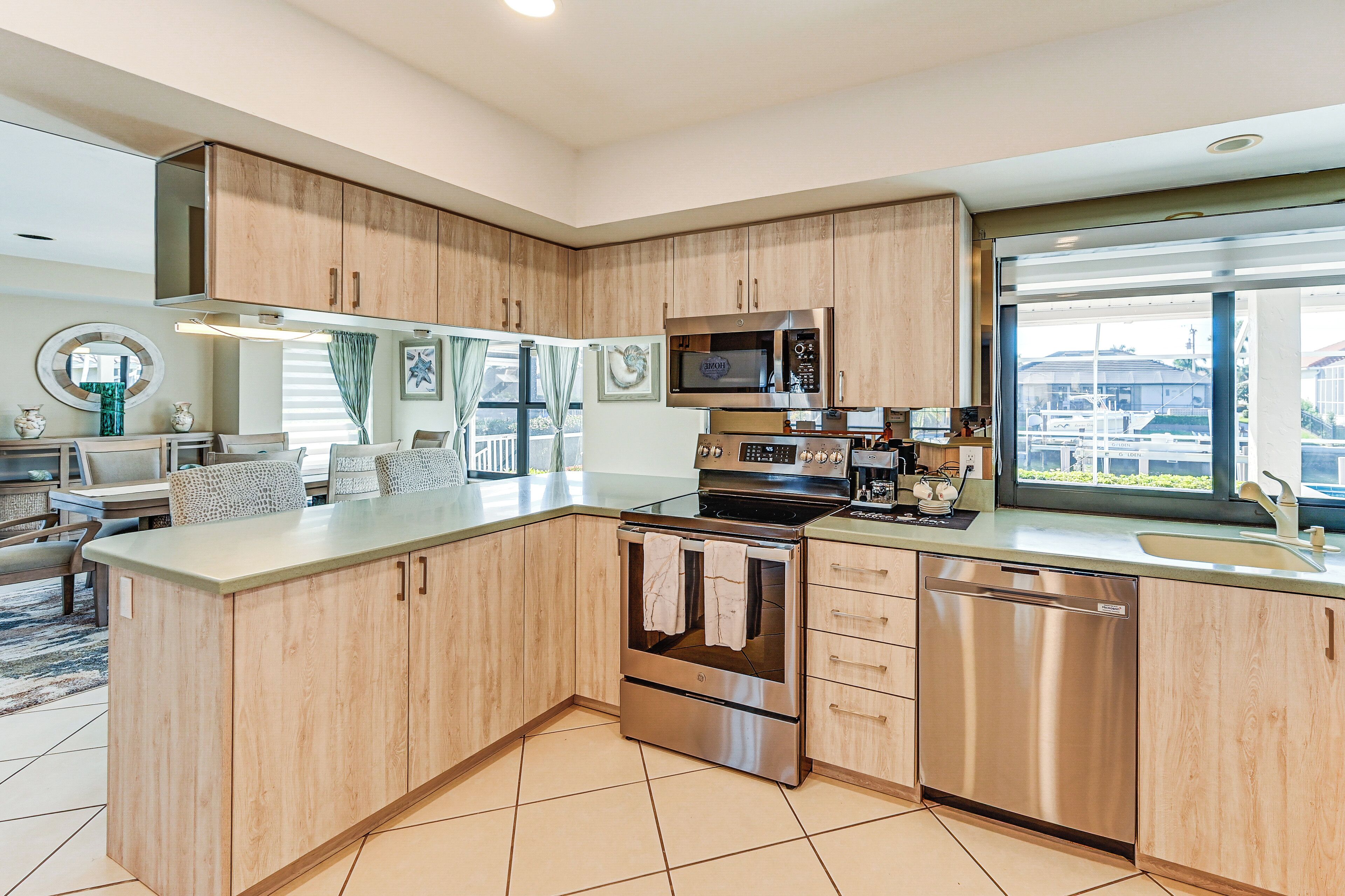 Una cocina moderna con armarios de madera, electrodomésticos de acero inoxidable y un amplio ventanal con vistas a la ciudad.
