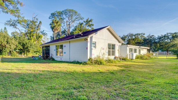 Une maison de plain-pied avec un toit à pignon, un porche à l’avant et un petit garage attenant.