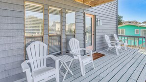 A porch with white Adirondack chairs and a wooden ceiling. - Steps to Sand! Home w/ 3 Decks in Sunset Beach (Sunset Beach)