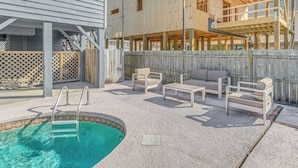 A swimming pool with a ladder, surrounded by outdoor furniture and a wooden deck. - Steps to Sand! Home w/ 3 Decks in Sunset Beach (Sunset Beach)