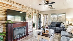 A living room with a fireplace, a ceiling fan, and a large window. - 2 Mi to Clear Lake: Pet-friendly Lakeport Retreat! (Lakeport)