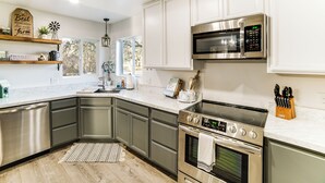 A modern kitchen with stainless steel appliances, white cabinetry, and a farmhouse-style decor. - 2 Mi to Clear Lake: Pet-friendly Lakeport Retreat! (Lakeport)