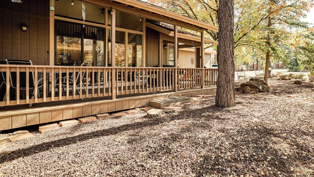 A wooden cabin with a covered porch, large windows, and a gravel ground. - 1 Mi to Golf Course: Wfh-friendly Pinetop Retreat (Pinetop)