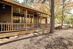 A wooden cabin with a covered porch, large windows, and a gravel ground. - 1 Mi to Golf Course: Wfh-friendly Pinetop Retreat (Pinetop)