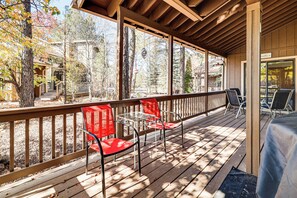A covered outdoor deck with wooden railings, metal chairs, and a table. - 1 Mi to Golf Course: Wfh-friendly Pinetop Retreat (Pinetop)