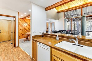 A kitchen with wooden cabinets, a dishwasher, and a large window overlooking a balcony. - 1 Mi to Golf Course: Wfh-friendly Pinetop Retreat (Pinetop)