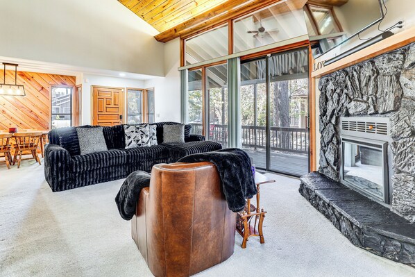 A modern living room with a sectional sofa, a leather ottoman, and a stone fireplace. - 1 Mi to Golf Course: Wfh-friendly Pinetop Retreat (Pinetop)