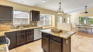 A kitchen with dark cabinetry, a granite countertop, and a central island. - Apopka Family Home w/ Yard, 13 Mi to Dtwn Orlando (Apopka)