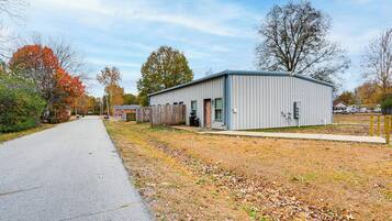 A single-story building with a flat roof, a covered outdoor area, and a paved driveway.