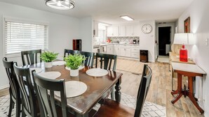 A dining area with a wooden table, chairs, and potted plants. - Bring Your Boat: Family Home Steps to Lake Greeson (Kirby)