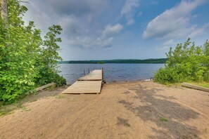 Une jetée en bois qui mène à un lac paisible, entouré d’une végétation luxuriante.