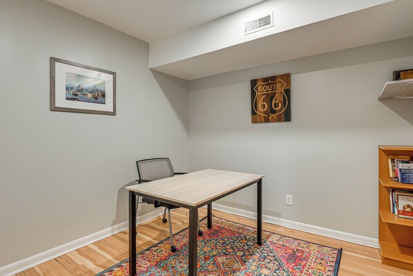 A room with a light-colored table, a chair, a patterned rug, a bookshelf, and two wall decorations. - 2 Mi to Lake Elkhorn Park: Family Gem w/ Deck! (Columbia)