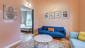 A living room with a blue sofa, a round coffee table, and a patterned rug. There are framed pictures on the wall and a decorative wall hanging. - 2 Mi to Lake Elkhorn Park: Family Gem w/ Deck! (Columbia)