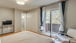 A bedroom with a bed, a TV on a stand, a chair, a sliding door to a balcony, and a ceiling light fixture. - 2 Mi to Lake Elkhorn Park: Family Gem w/ Deck! (Columbia)