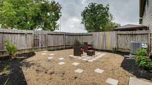 Ein Garten mit Holzzaun, Gartenmöbeln und einer Schotterterrasse.