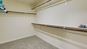Ein Schrank mit drei Holzböden und einer Kleiderstange.