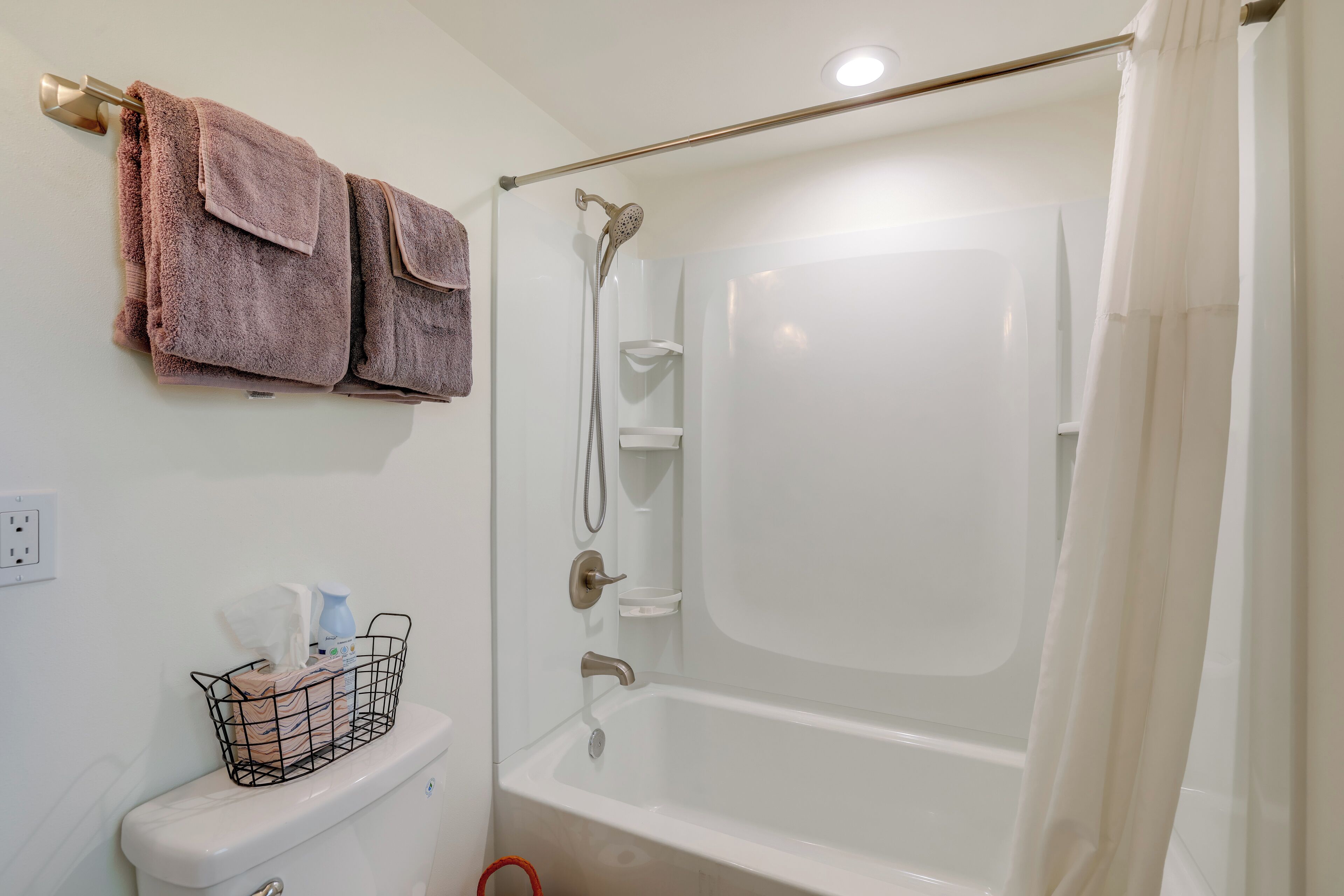 Ein Badezimmer mit Toilette, einer Duschkabine mit Glastür und einem Handtuchhalter mit zwei Handtüchern.