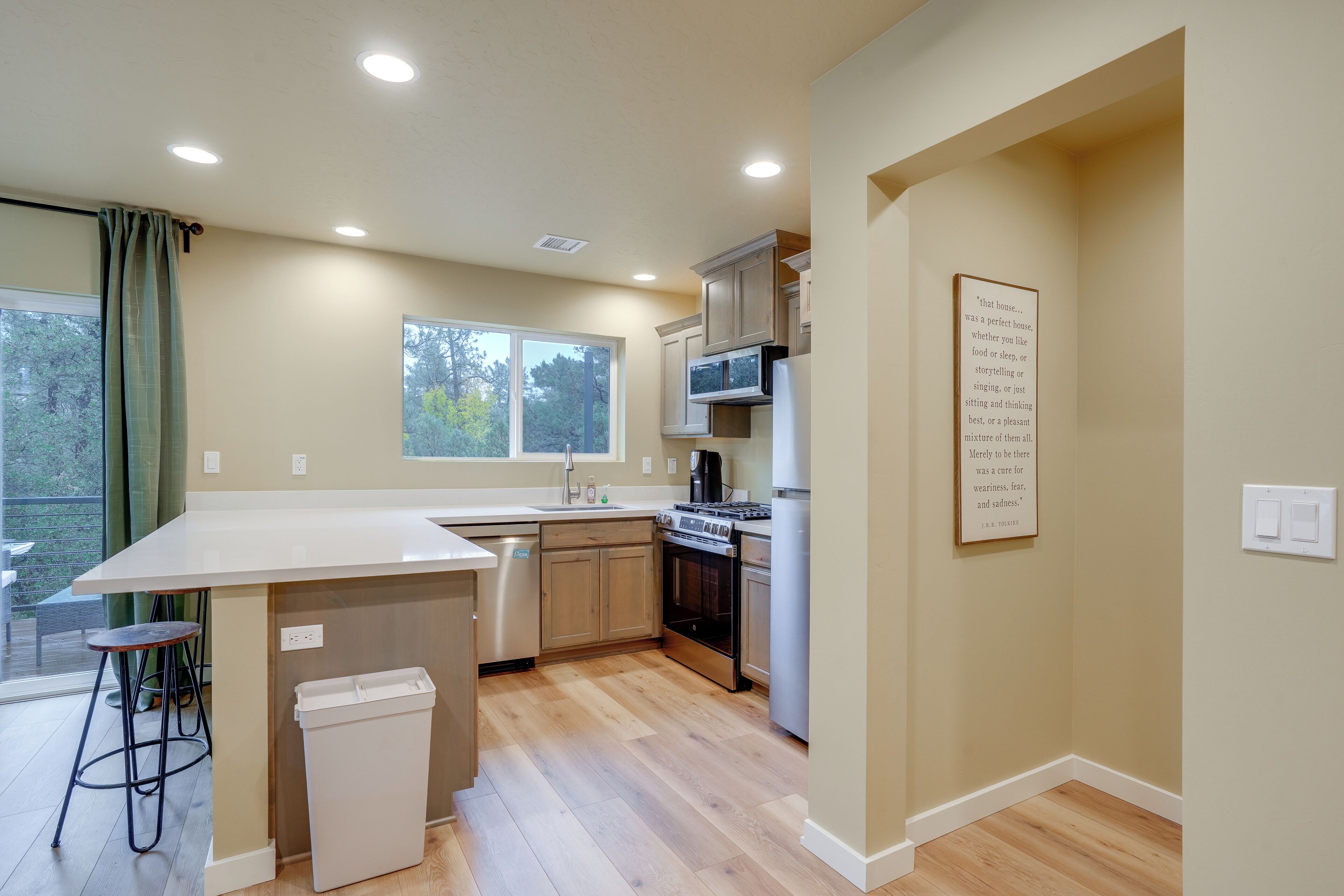 A modern kitchen with a central island, built-in appliances, and a large window.