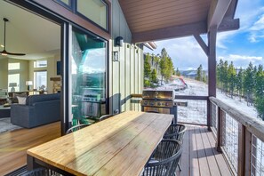 A wooden deck with a table and chairs, a grill, and a view of a snowy mountain landscape. - Luxe Home w/ Hot Tub and Views in Winter Park! (Winter Park)
