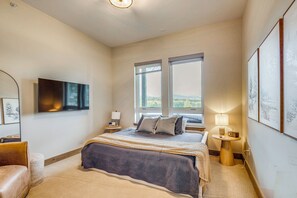 A bedroom with a bed, a TV, a window, and a lamp. - Luxe Home w/ Hot Tub and Views in Winter Park! (Winter Park)
