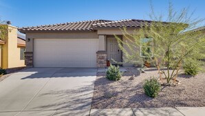 A single-story house with a tiled roof, a garage door, and a small garden with shrubs and a tree. - 6 Mi to State Park: Newly Built Home in Benson! (Benson)