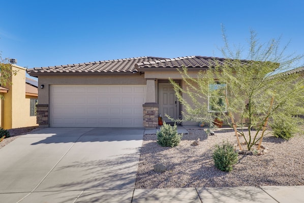 A single-story house with a tiled roof, a garage door, and a small garden with shrubs and a tree. - 6 Mi to State Park: Newly Built Home in Benson! (Benson)