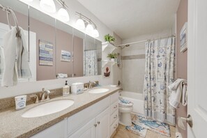 A bathroom with two sinks, a toilet, a shower, and a large mirror. - Heart of Anchorage! Home Near Shops & Eats (Anchorage)