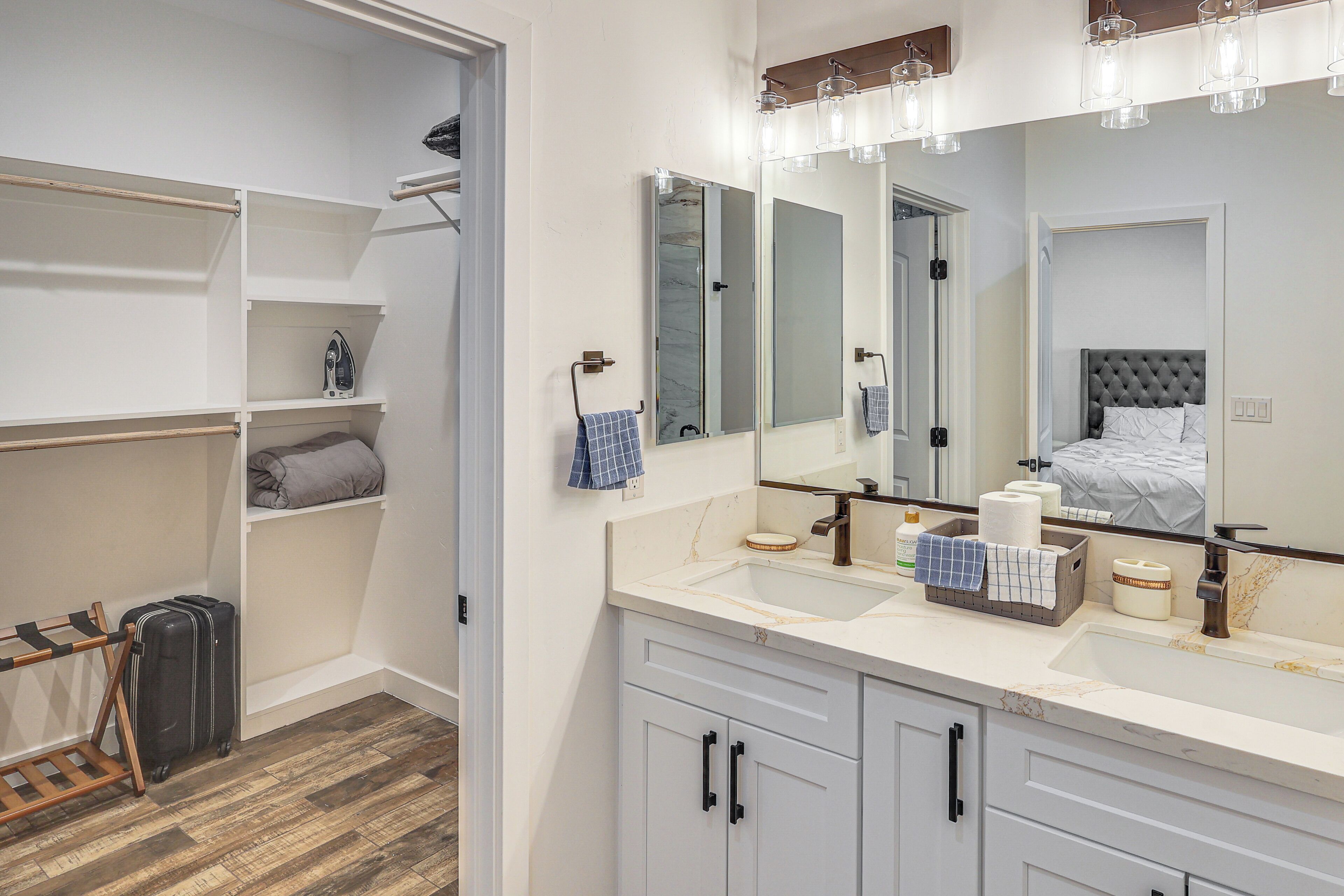 Une salle de bain moderne avec un grand miroir, un lavabo et un espace douche.