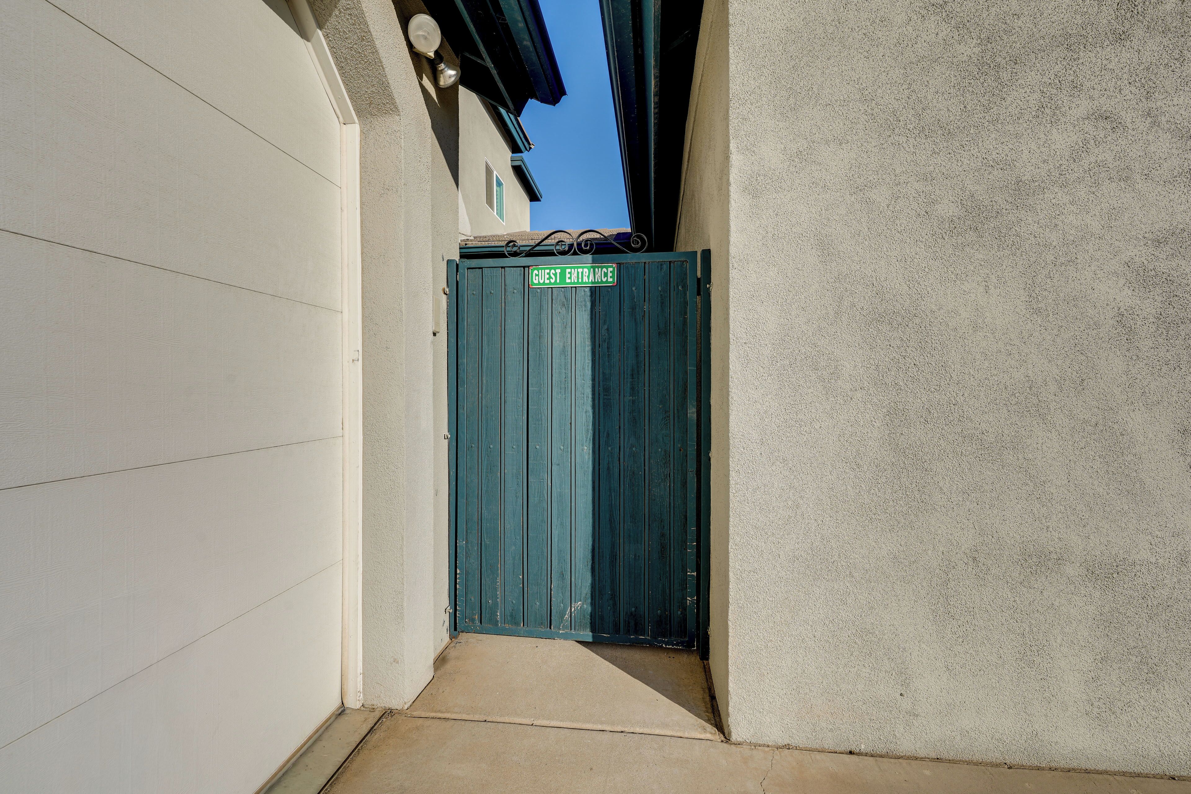 Un couloir étroit avec une porte verte portant l’inscription « ENTRÉE DES VISITEURS ».
