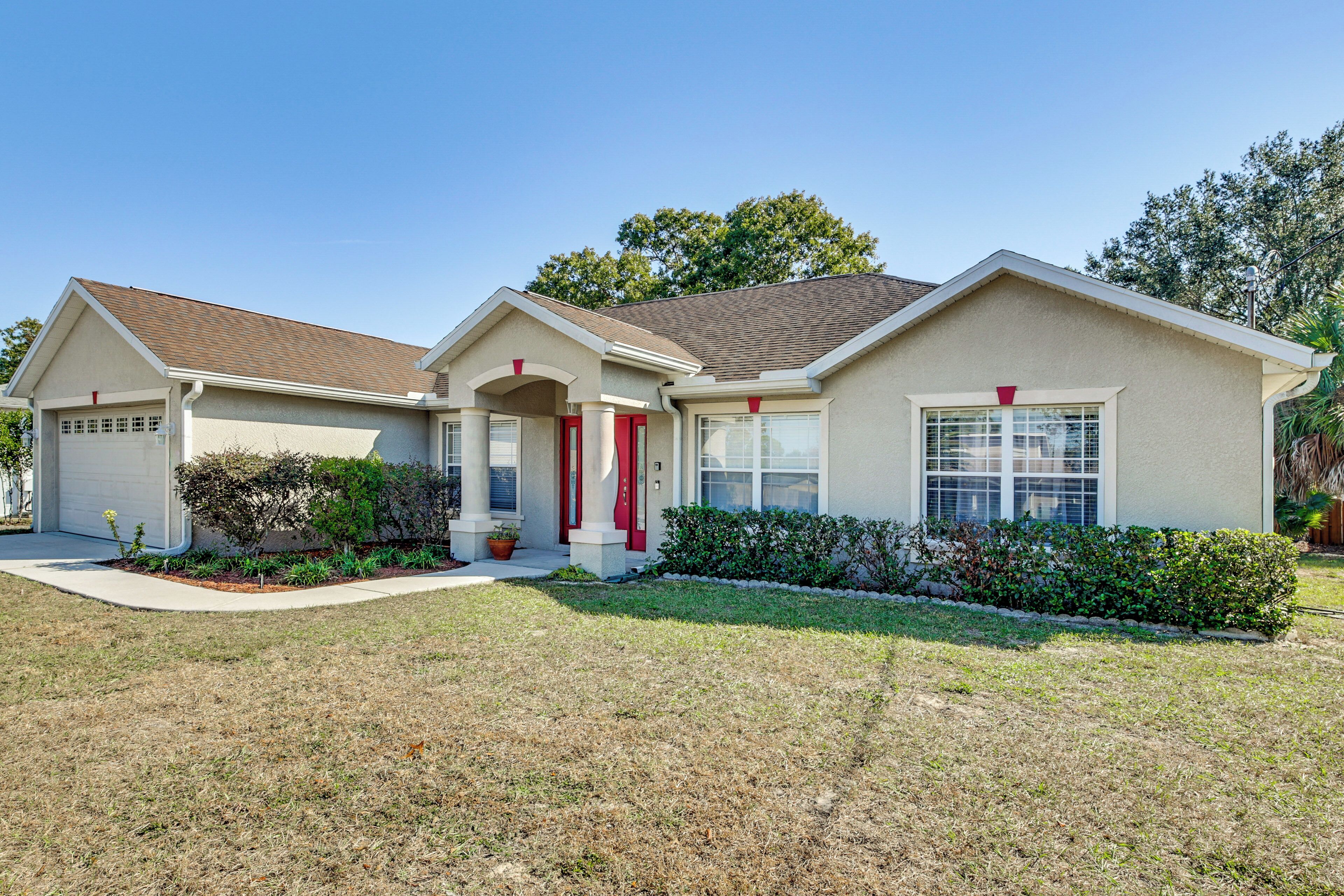 A two-story house with a front porch, a garage, and a well-maintained lawn.