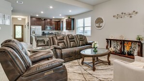 A spacious living room with leather recliners, a glass coffee table, and a decorative console table. - Lake Conroe Home w/ Resort-style Perks & Patio (Montgomery)