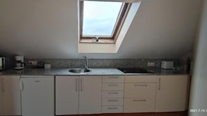A compact kitchen with a skylight, a built-in sink, and a microwave. - hotel balcon de san bartolo (Barreiros)