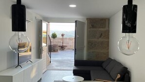 Un espace de vie moderne comprenant un coin repas, un canapé et une vue sur l’extérieur.
