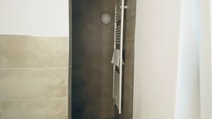 Een smalle gang met een witte radiator en een handdoek eraan.